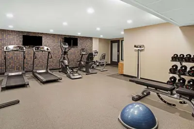 a gym with several treadmills and exercise machines at La Quinta Inn & Suites by Wyndham Denver Aurora Medical in Aurora