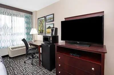 a hotel room with a flat screen tv and a desk at La Quinta Inn & Suites by Wyndham Denver Aurora Medical in Aurora