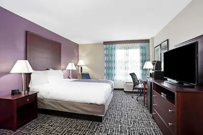 a hotel room with a bed and a flat screen tv at La Quinta Inn & Suites by Wyndham Denver Aurora Medical in Aurora