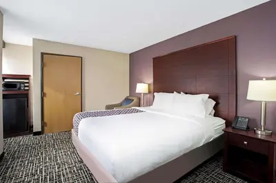 a hotel room with a large bed and a kitchen at La Quinta Inn & Suites by Wyndham Denver Aurora Medical in Aurora