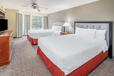 a hotel room with two beds and a flat screen tv at Homewood Suites by Hilton Denver - Littleton in Littleton