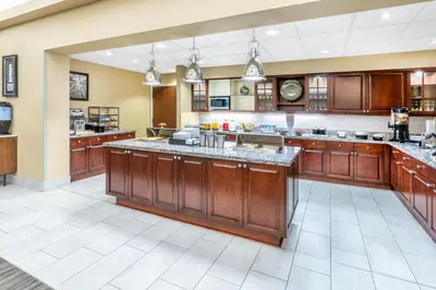a large kitchen with wooden cabinets and a large island at Homewood Suites by Hilton Denver - Littleton in Littleton