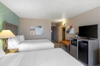 a hotel room with two beds and a flat screen tv at Comfort Inn & Suites Boulder in Boulder