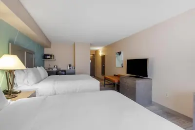 a hotel room with two beds and a flat screen tv at Comfort Inn & Suites Boulder in Boulder