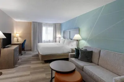 a hotel room with a bed and a couch at Comfort Inn & Suites Boulder in Boulder