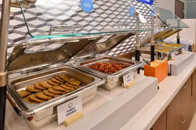 a buffet line with trays of food on a counter at Holiday Inn Express & Suites Broomfield by IHG in Broomfield