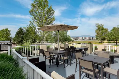 a patio with tables and chairs and an umbrella at Residence Inn Denver North/Westminster in Westminster