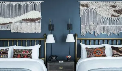 two beds in a bedroom with blue walls at The Armstrong Hotel in Fort Collins
