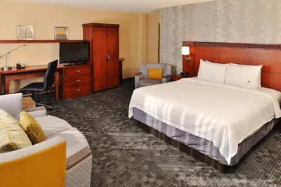 a hotel room with a bed and a television at Courtyard by Marriott Denver Cherry Creek in Denver