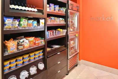 a store with an orange wall and an open refrigerator at Courtyard by Marriott Denver Cherry Creek in Denver