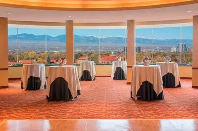 a set of tables in a room with mountains in the background at Courtyard by Marriott Denver Cherry Creek in Denver