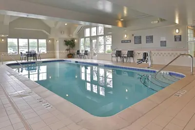 a large swimming pool with blue water in a building at Residence Inn by Marriott Loveland Fort Collins in Loveland