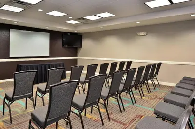 a conference room with chairs and a screen at Residence Inn by Marriott Loveland Fort Collins in Loveland