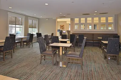 a waiting room with tables and chairs in a hospital at Residence Inn by Marriott Loveland Fort Collins in Loveland