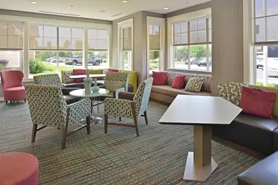 a waiting room with a couch and tables and chairs at Residence Inn by Marriott Loveland Fort Collins in Loveland