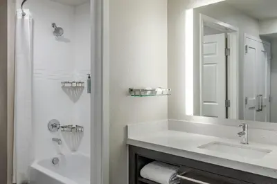 a white bathroom with a sink and a mirror at Residence Inn by Marriott Denver Airport at Gateway Park in Aurora