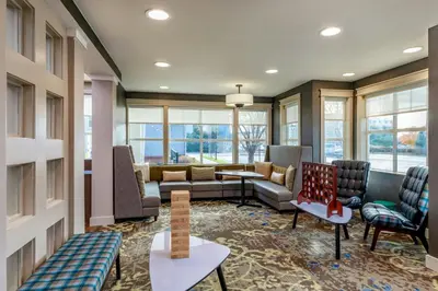 a lobby with a waiting room with a couch and chairs at Residence Inn by Marriott Denver Airport at Gateway Park in Aurora