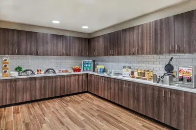 a kitchen with wooden cabinets and a counter with food at Residence Inn by Marriott Denver Airport at Gateway Park in Aurora