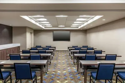 a classroom with tables and chairs and a screen at Residence Inn by Marriott Denver Airport at Gateway Park in Aurora