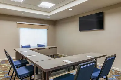 a conference room with tables and chairs and a flat screen tv at Residence Inn by Marriott Denver Airport at Gateway Park in Aurora