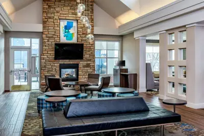 a living room with tables and a fireplace at Residence Inn by Marriott Denver Airport at Gateway Park in Aurora