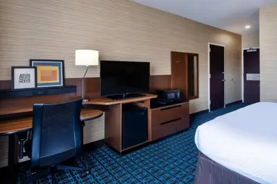 a hotel room with a bed and a desk with a computer at Fairfield Inn & Suites by Marriott Denver Aurora/Medical Center in Aurora