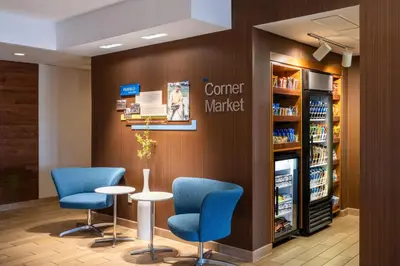 a waiting room with blue chairs and a counter in a store at Fairfield Inn & Suites by Marriott Denver Aurora/Medical Center in Aurora