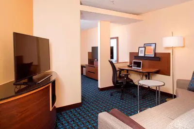 a hotel room with a bed and a desk with a television at Fairfield Inn & Suites by Marriott Denver Aurora/Medical Center in Aurora
