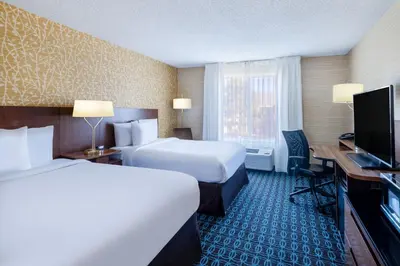 a hotel room with two beds and a desk and a television at Fairfield Inn & Suites by Marriott Denver Aurora/Medical Center in Aurora