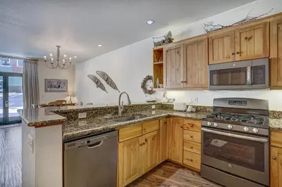 a kitchen with wooden cabinets and stainless steel appliances at East Keystone by Vail Resorts in Keystone
