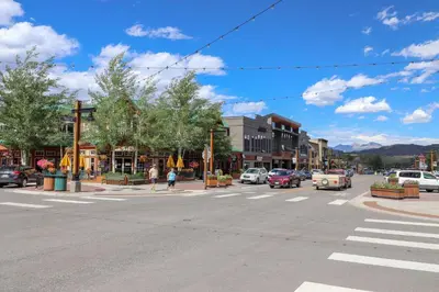 an empty street in a small town with a crosswalk at Condo Right On Main Street By Daniel in Frisco