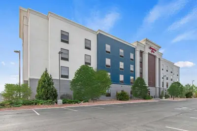 a large white building with a blue at Hampton Inn Denver Northeast-Brighton in Brighton