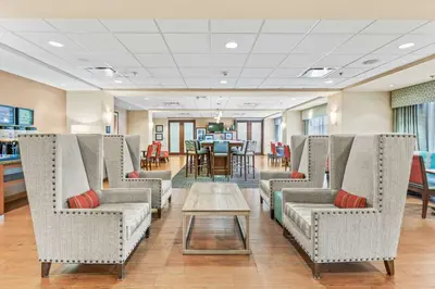 a waiting room with chairs and a table at Hampton Inn Denver Northeast-Brighton in Brighton