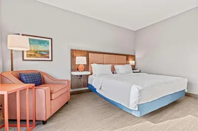 a hotel room with a bed and a chair at Hampton Inn Denver Northeast-Brighton in Brighton