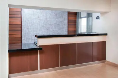 a dressing room with a mirror and wooden cabinets at Fairfield Inn & Suites Greeley in Greeley