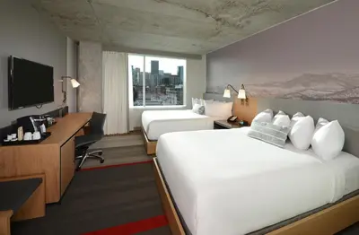 a hotel room with a bed and a desk and a television at Hotel Indigo Denver Downtown - Union Station by IHG in Denver