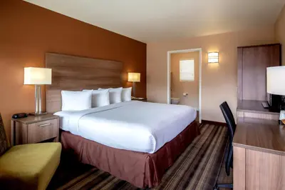 a hotel room with a large bed and a chair at Boulder University Inn in Boulder