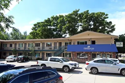 a building with cars parked in a parking lot at Boulder University Inn in Boulder