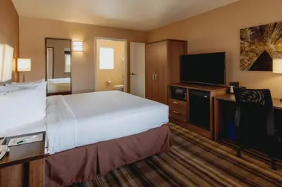 a hotel room with a bed and a flat screen tv at Boulder University Inn in Boulder