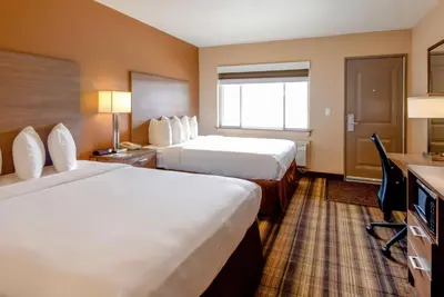 a hotel room with two beds and a television at Boulder University Inn in Boulder