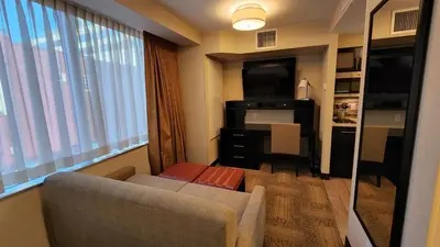 a living room with a couch and a table and a window at Staybridge Suites Denver Downtown by IHG in Denver
