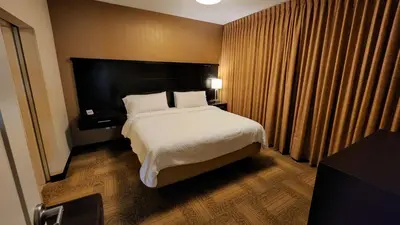 a hotel room with a bed and a large window at Staybridge Suites Denver Downtown by IHG in Denver