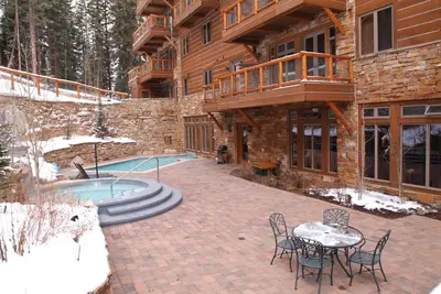 a patio with a table and chairs next to a house at Timbers & Lone Eagle by Vail Resorts in Keystone