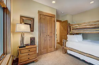 a bedroom with a bed and a table with a lamp at Timbers & Lone Eagle by Vail Resorts in Keystone