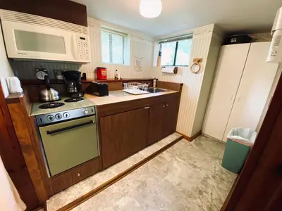 a kitchen with a stove and a microwave at Foot of the Mountain Motel in Boulder