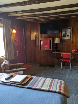a hotel room with a bed with a tray on it at Foot of the Mountain Motel in Boulder