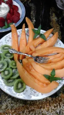 a plate of carrots and kiwis on a table at The Silk Pincushion in Golden