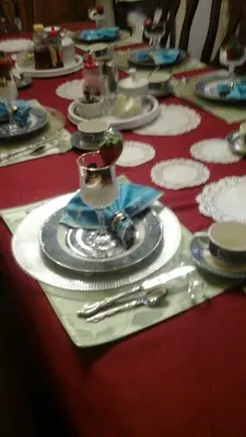 a table with plates and silverware on a red table cloth at The Silk Pincushion in Golden