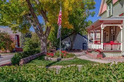 a house with a american flag in a flower garden at The Silk Pincushion in Golden