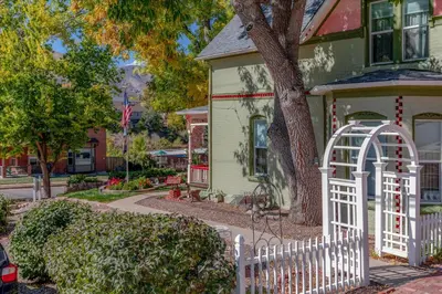 a white fence in front of a house at The Silk Pincushion in Golden